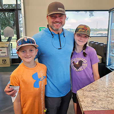 Dad with kids learning about the sporting lifestyle.